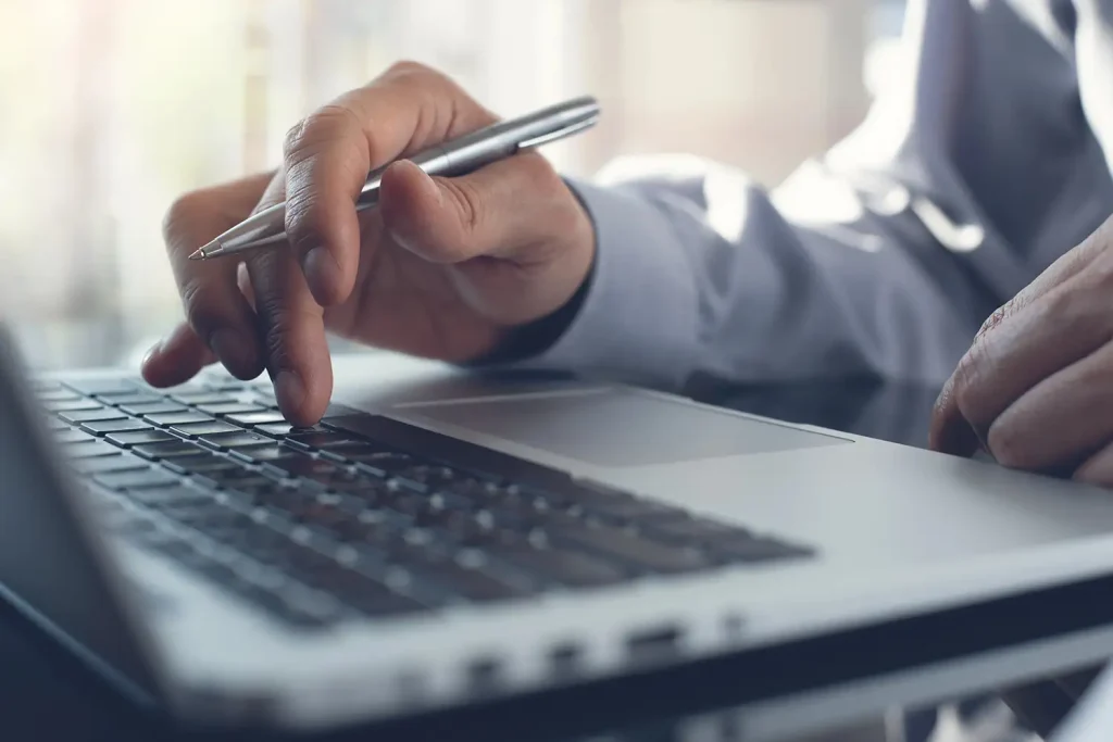 Homme avec un crayon sur son laptop
